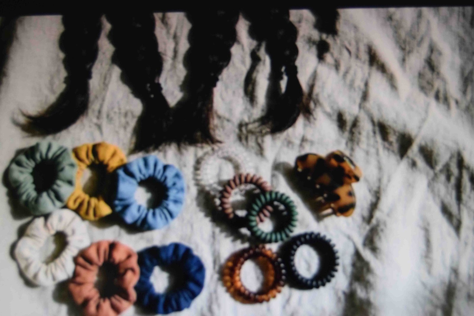 Fabric elastics and coil ties laid out as alternatives for braid ends
