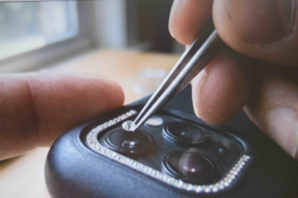 Close view of crystals being placed on a bedazzled phone case