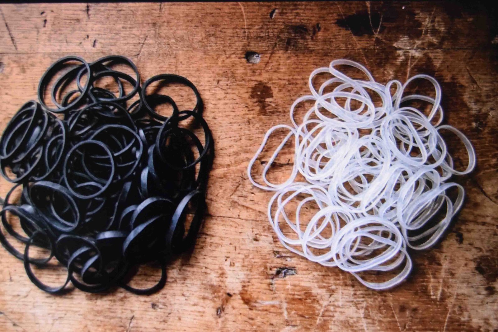 Black and clear elastic bands sorted into two separate piles