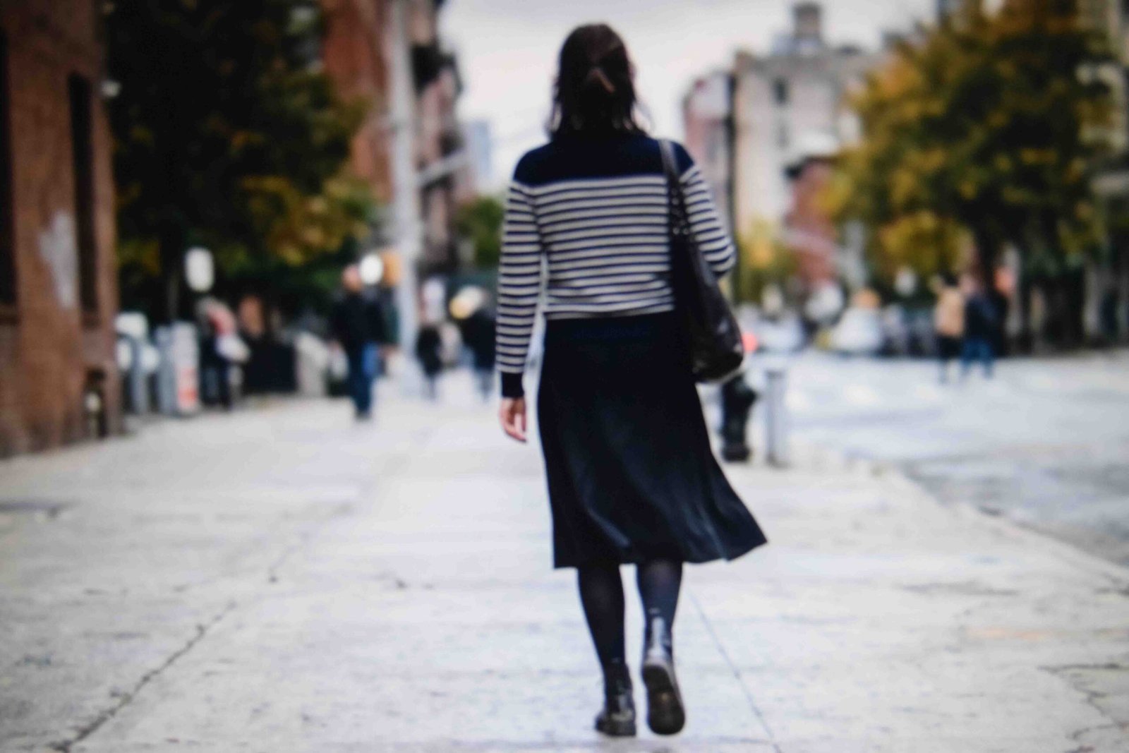 A striped top with a black skirt and boots as a stripped back version