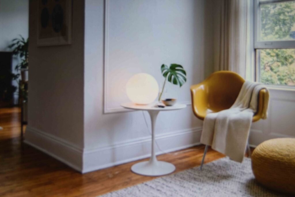 Funky living room ideas shown through a globe lamp tulip table and moulded chair in one corner