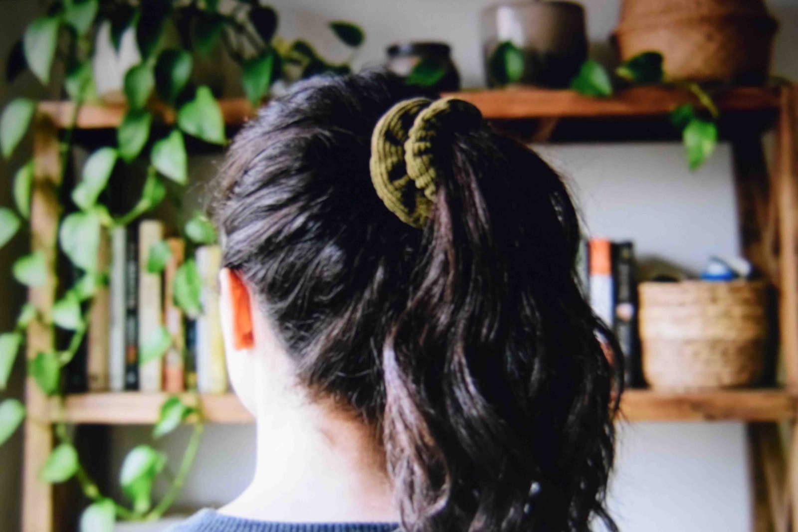 A high ponytail tied with a thick scrunchie showing lift at the roots
