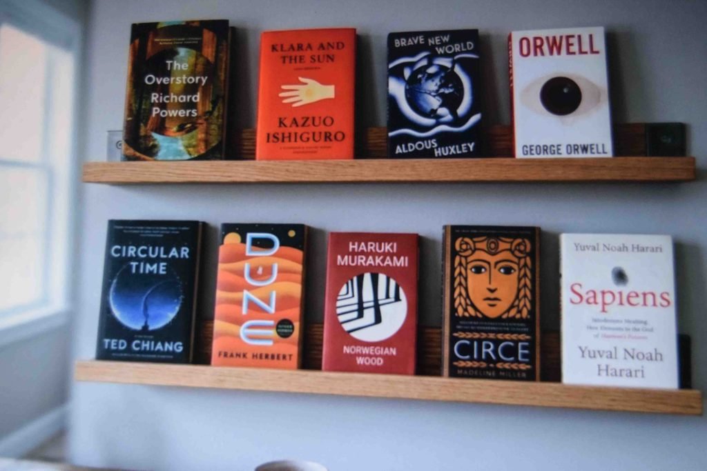 Wall mounted ledges holding books cover outward above a home learning desk