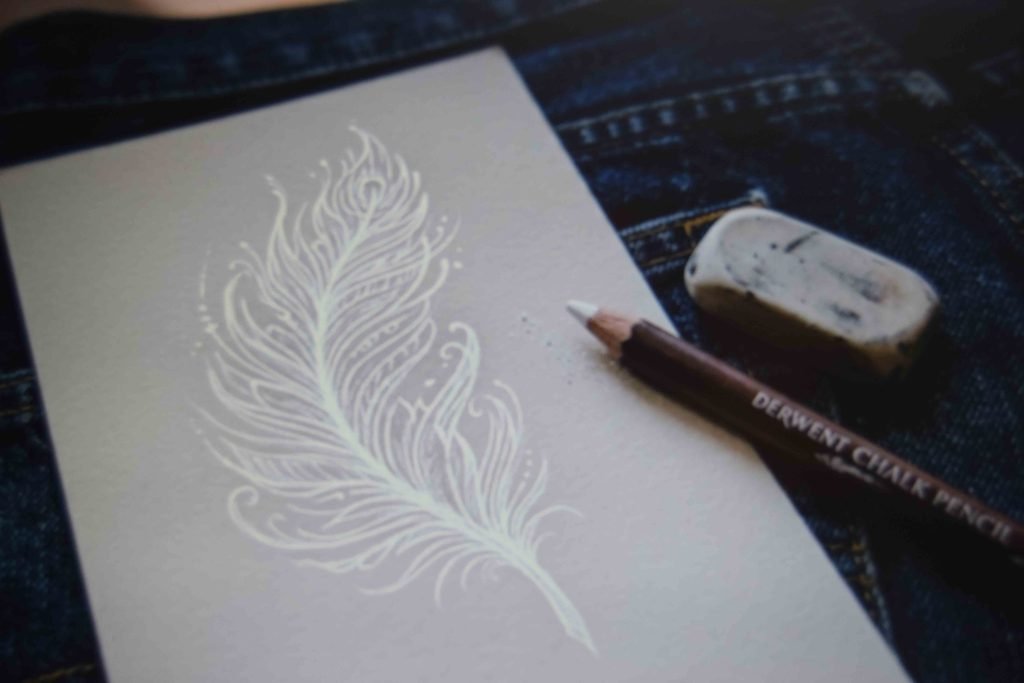A paper sketch placed on a denim pocket to plan the design before painting