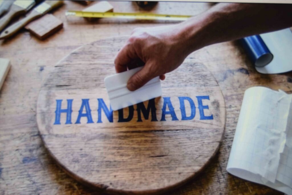 Vinyl lettering being applied to a wooden lid for a graduation keepsake box