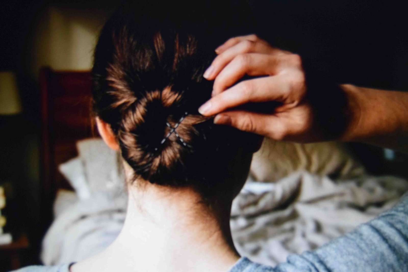A low coiled bun secured at the nape with two crossed pins