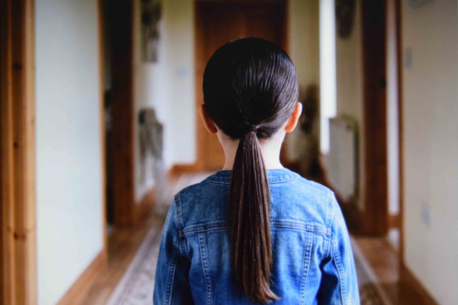 Nape-height ponytail smoothed at the crown and sitting above a jacket collar
