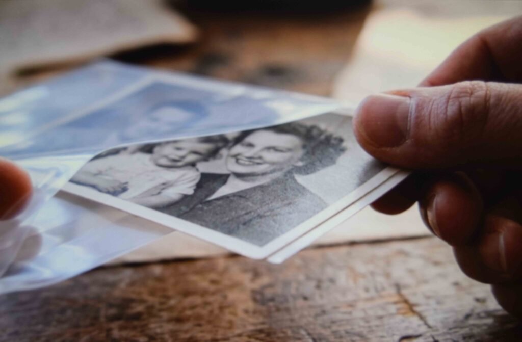 A photograph sliding into an archival sleeve to stop it fading inside a keepsake box