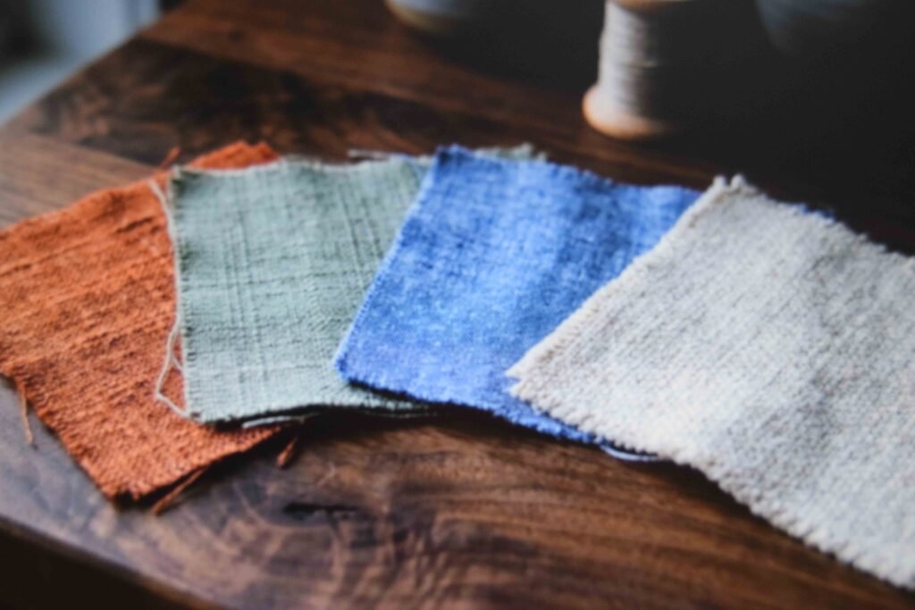 Terracotta sage and dusty blue fabric swatches arranged on walnut to show a warm retro palette