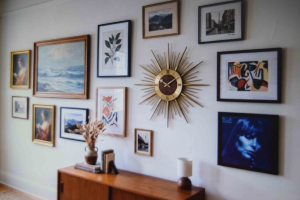 A gallery wall of frames broken up by a round sunburst clock and a framed album cover