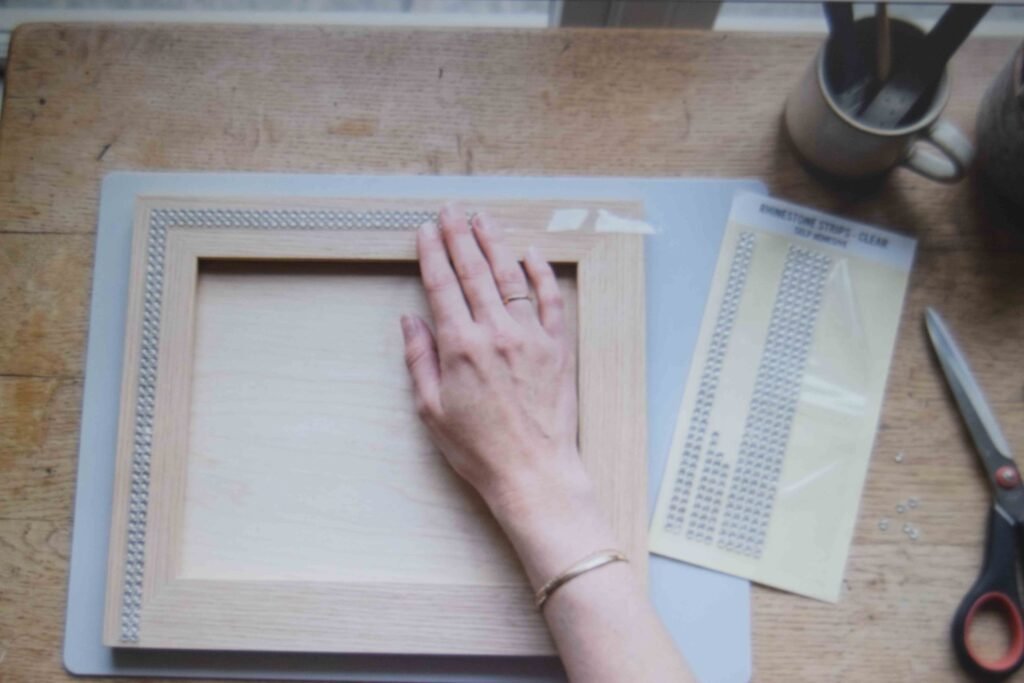 Adhesive strips applied to a frame as one of several rhinestone craft ideas