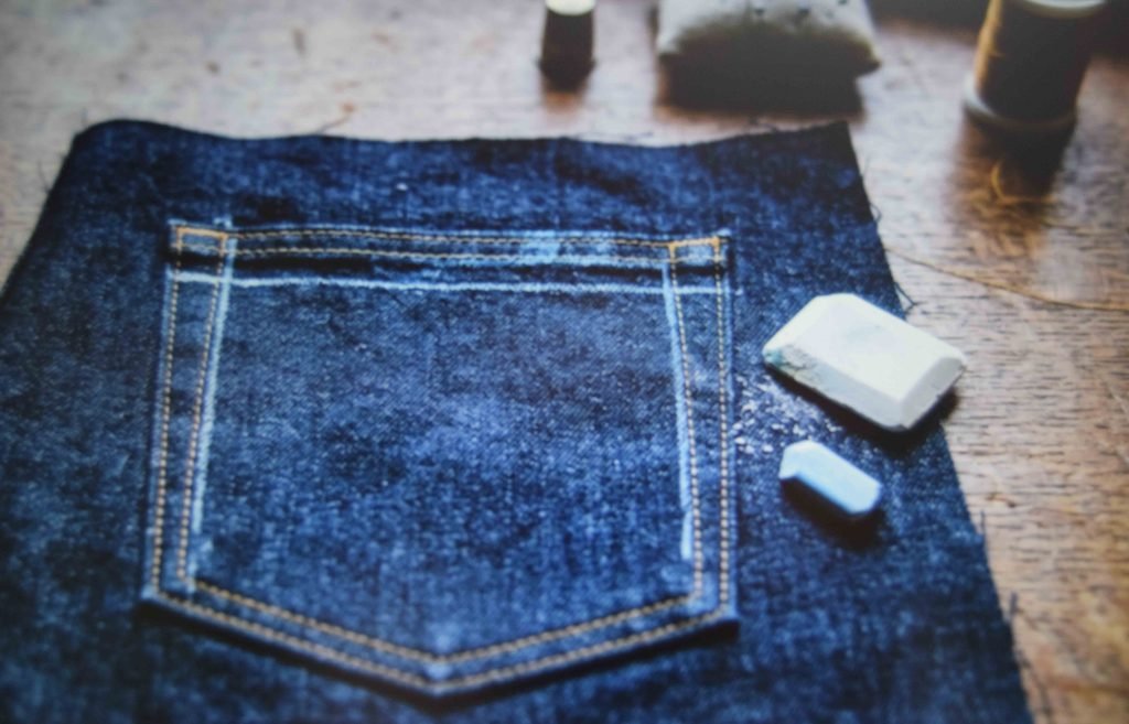 Chalk guidelines marked inside a jean pocket to keep the design within the stitching