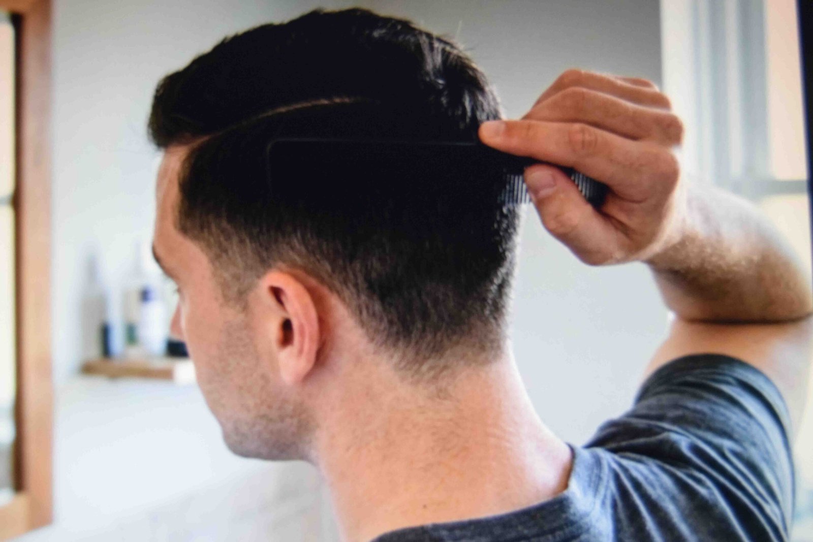 A fine tooth comb setting a side part through a tapered short cut