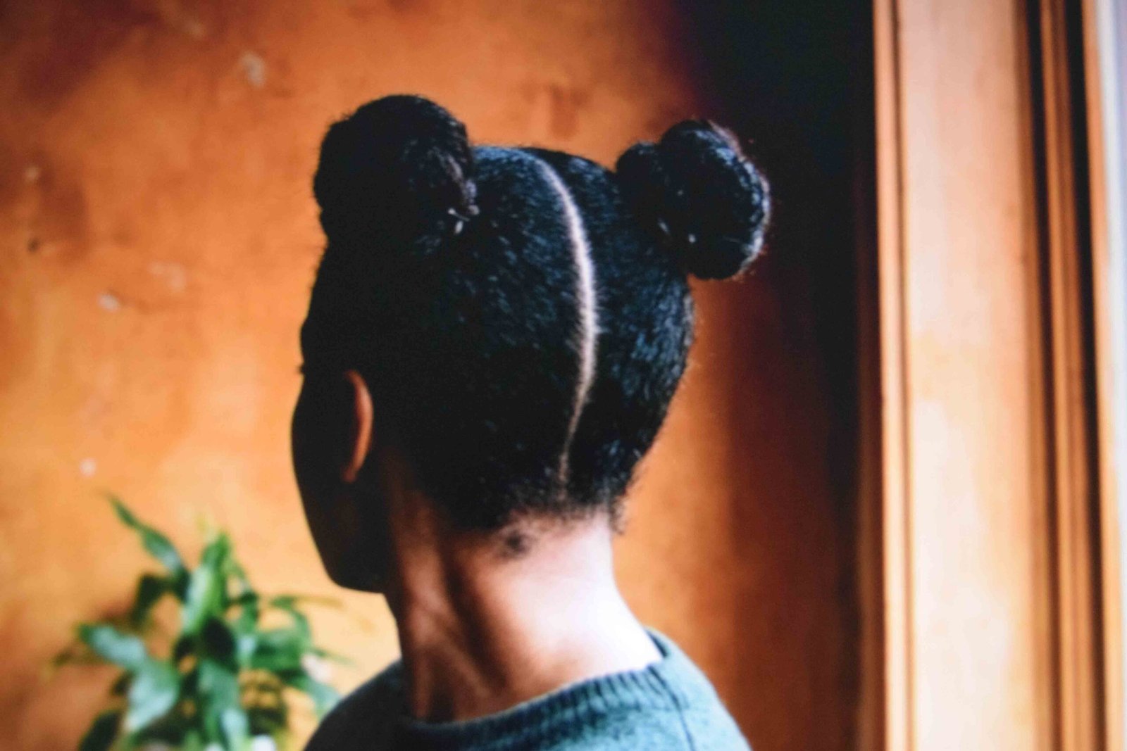 Two coiled space buns sitting level either side of a centre part