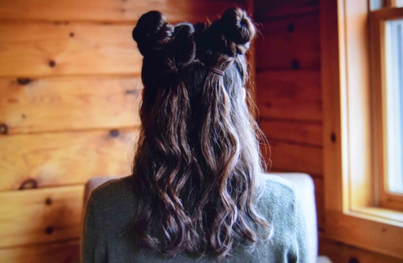 Two twisted space buns worn above hair left down at the back