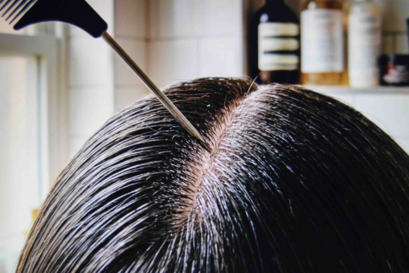 A tail comb drawing a straight middle part in one continuous stroke