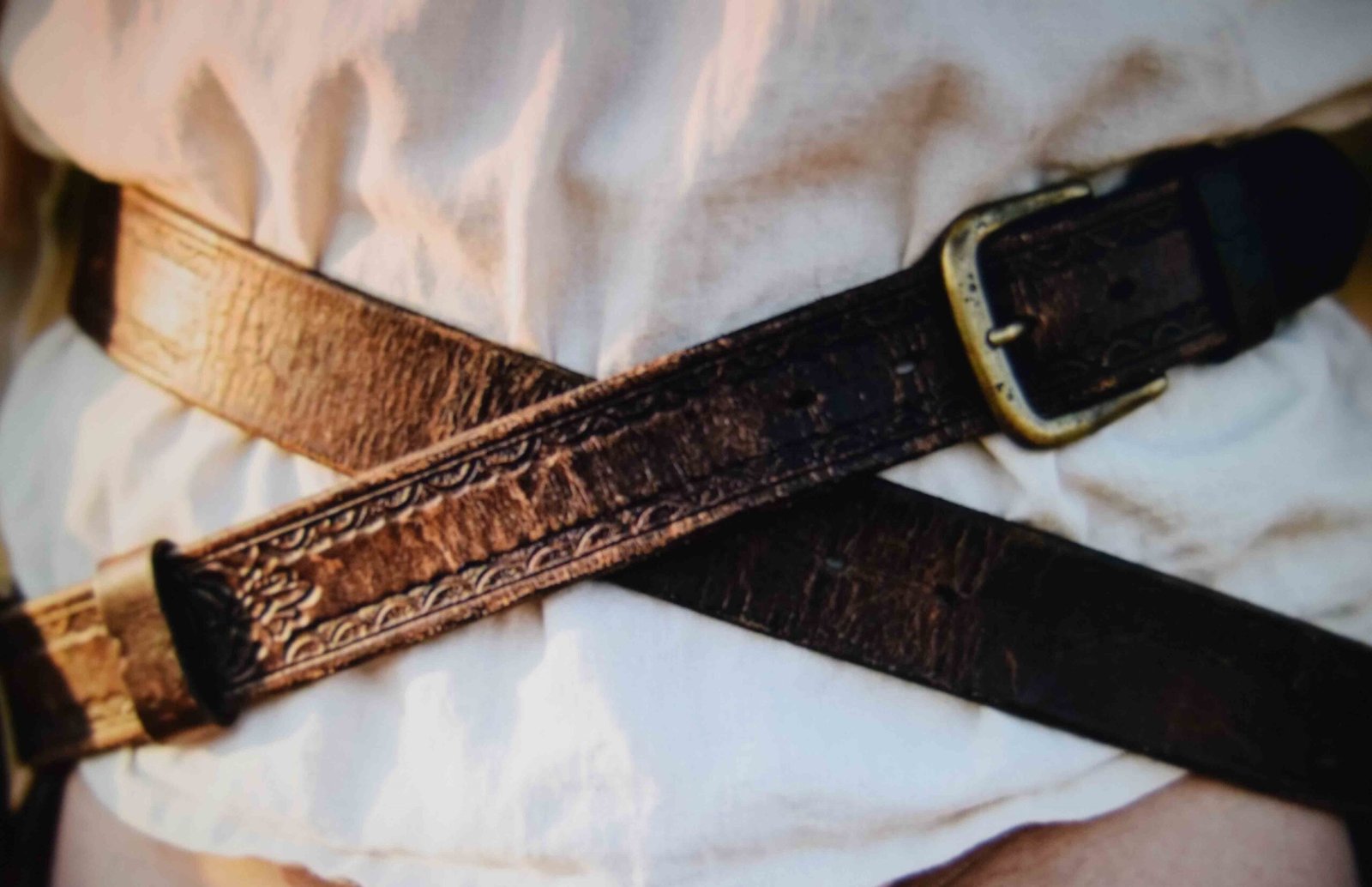 Two belts crossed low on the hips to shape a loose shirt