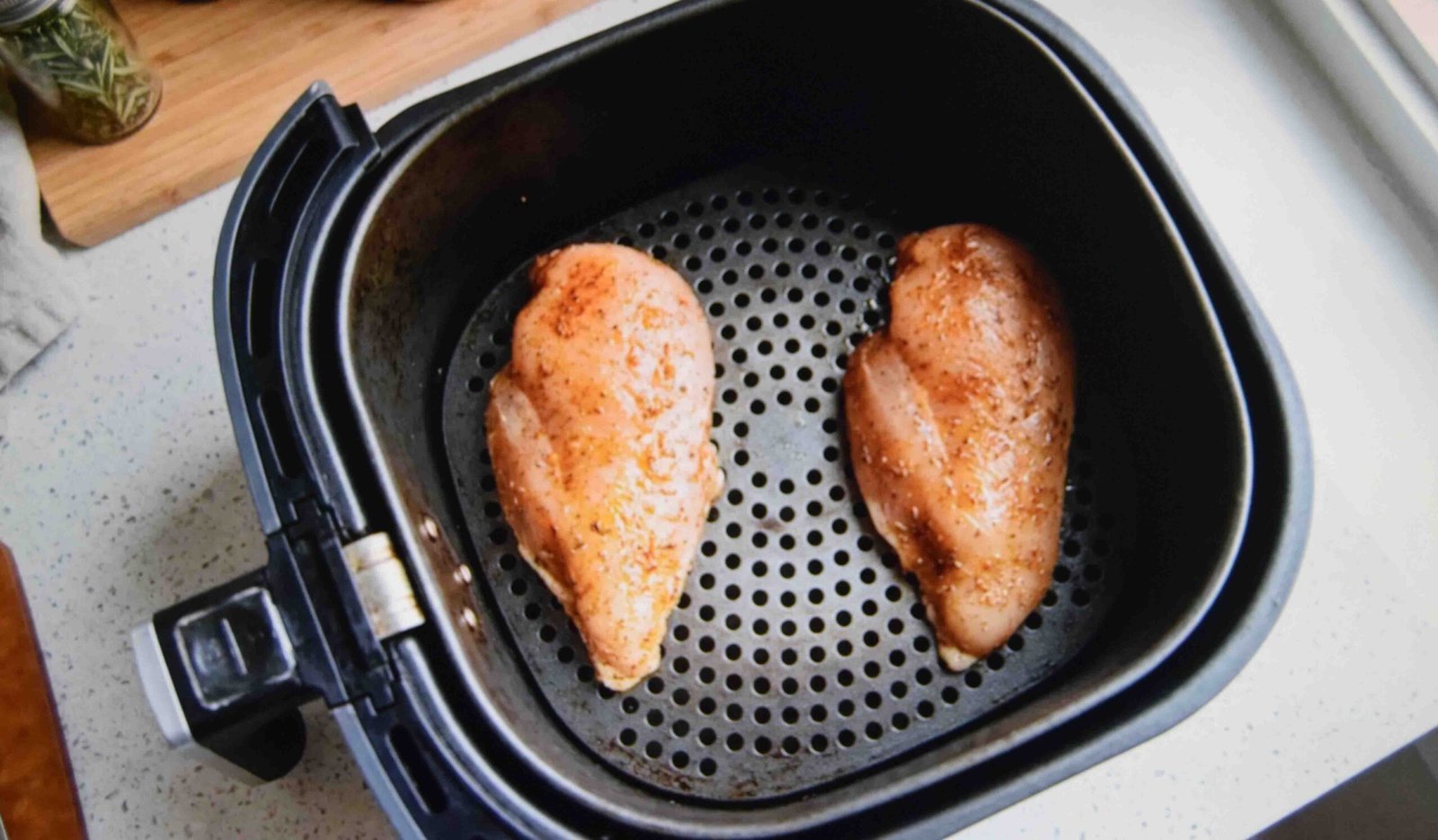 Chicken breasts spaced apart in the basket so hot air can circulate