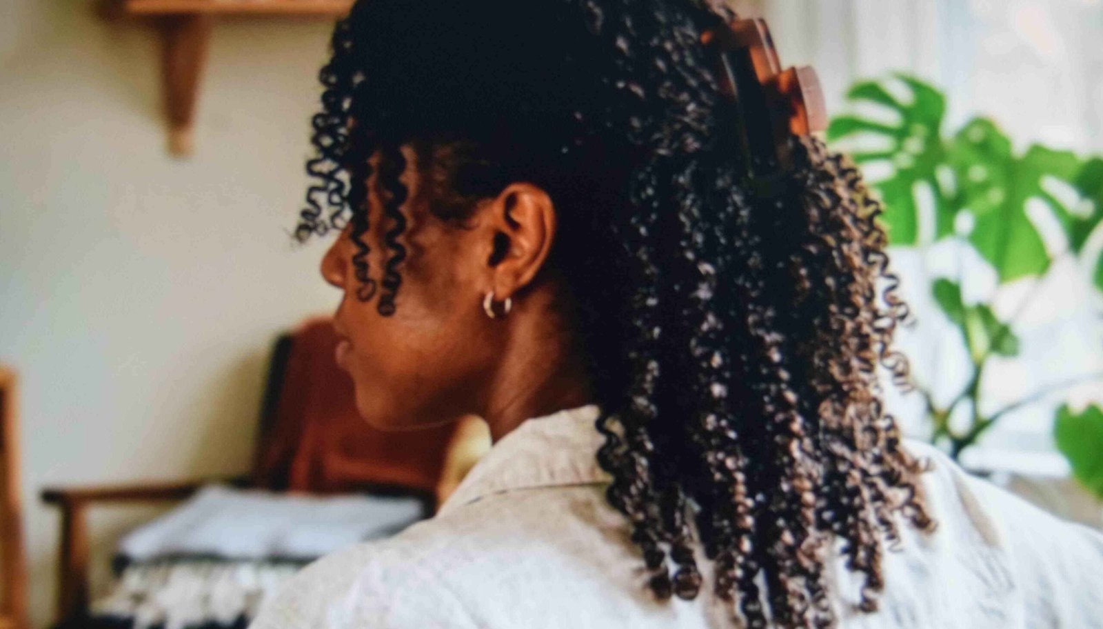 Half up claw clip set back from the hairline on defined coils so the front curls keep their volume