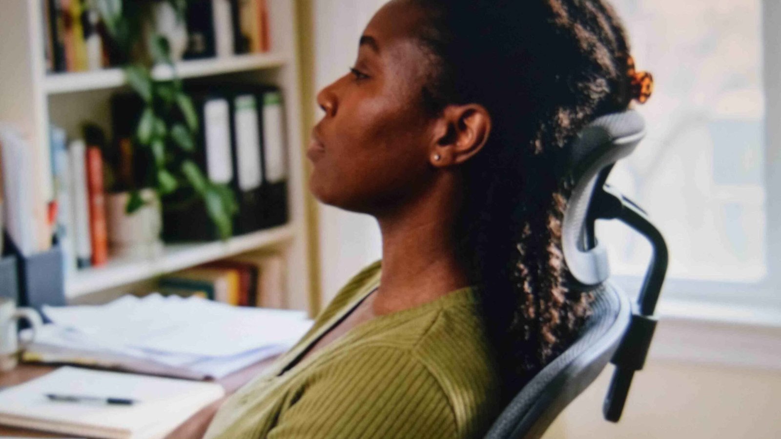 Shallow flat back claw clip lying close to the head as a woman leans against a desk chair