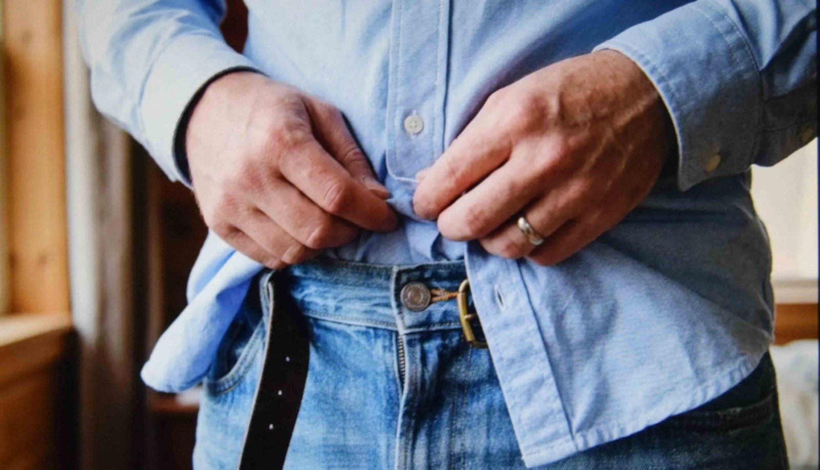 A front tuck showing how to style baggy jeans for ladies without losing the waist