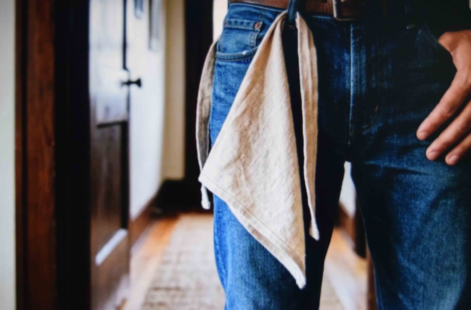 Small cotton square folded into a triangle and hung from front belt loops over one thigh