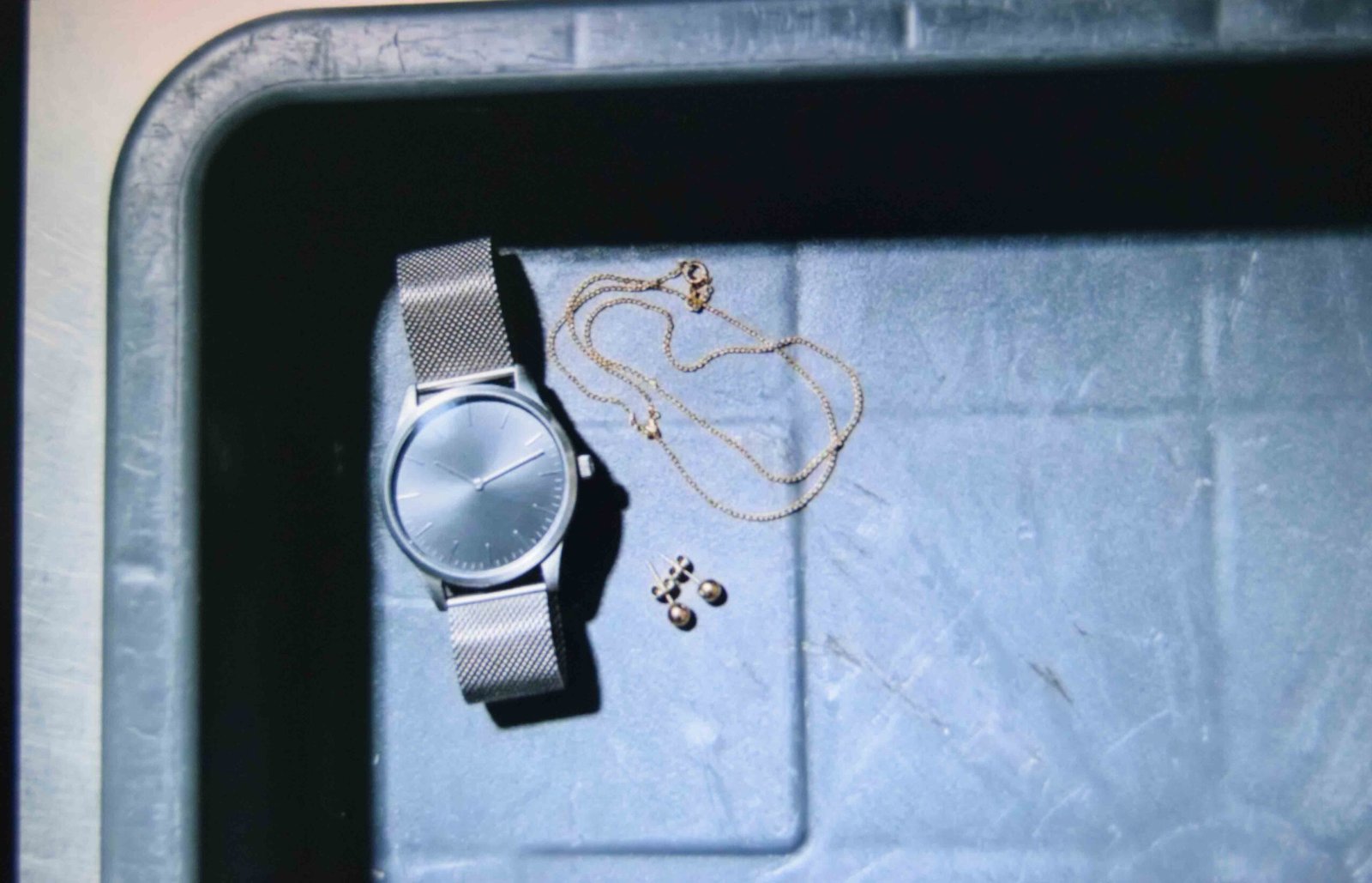Minimal jewellery kept to studs and a watch for an easy security check