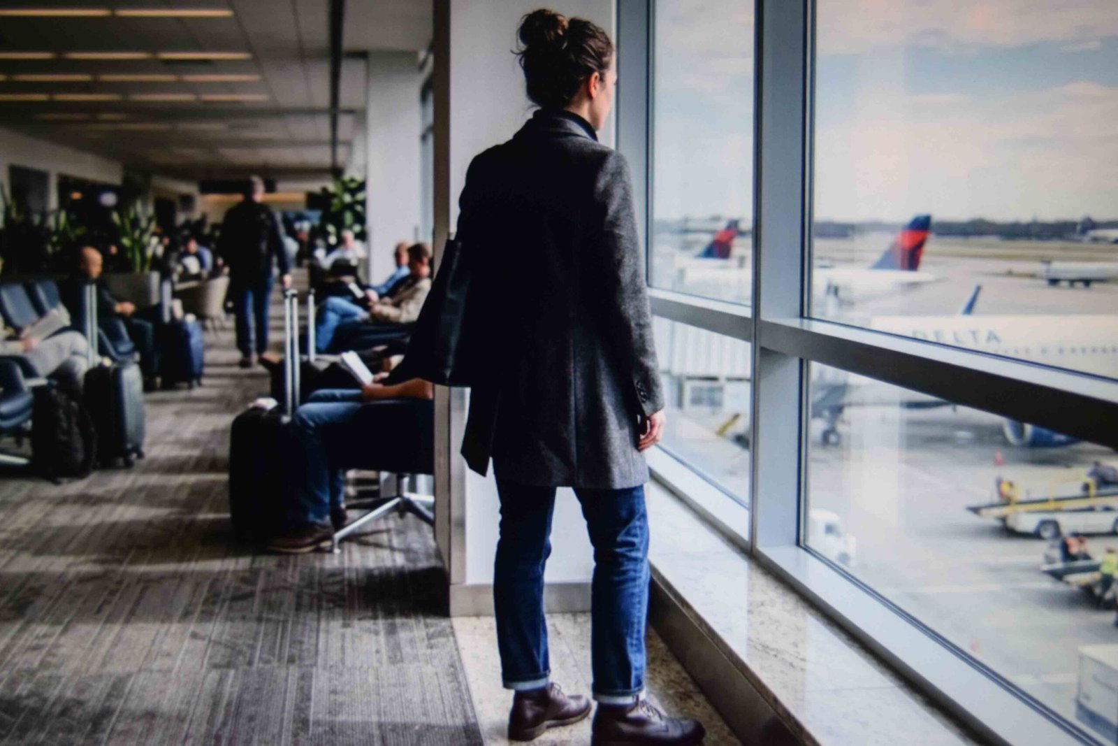 Dark wash straight jeans styled into polished outfits for airport travel