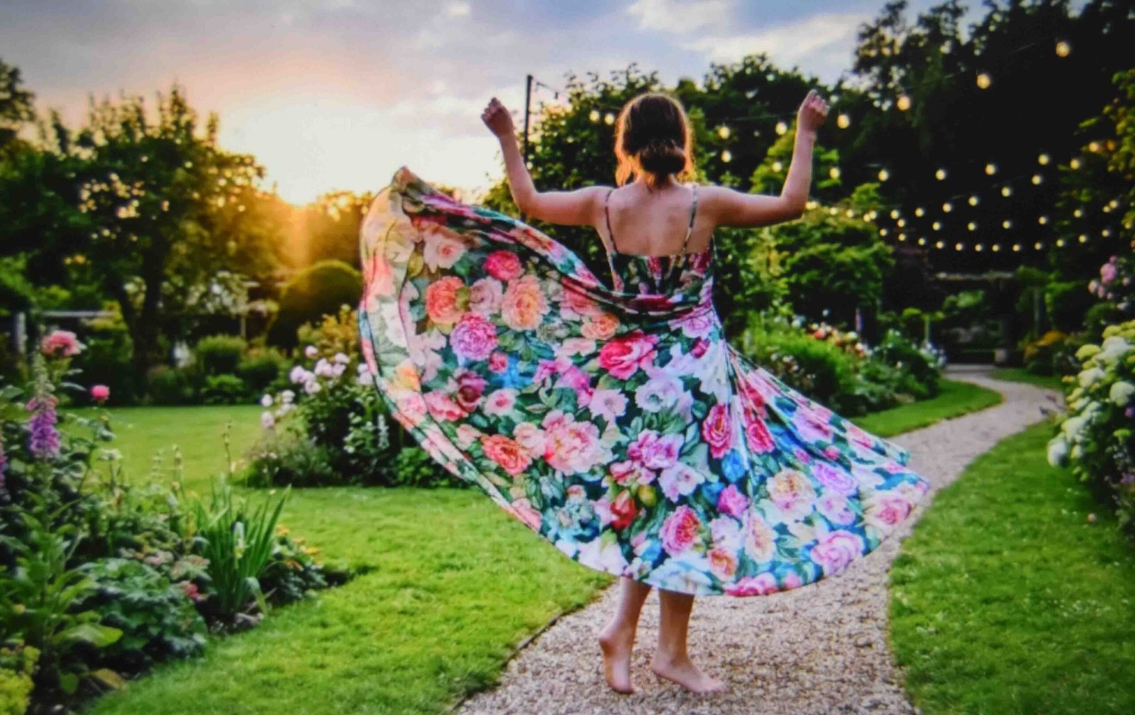 A plus size garden party dress in a fluid midi length photographed on grass