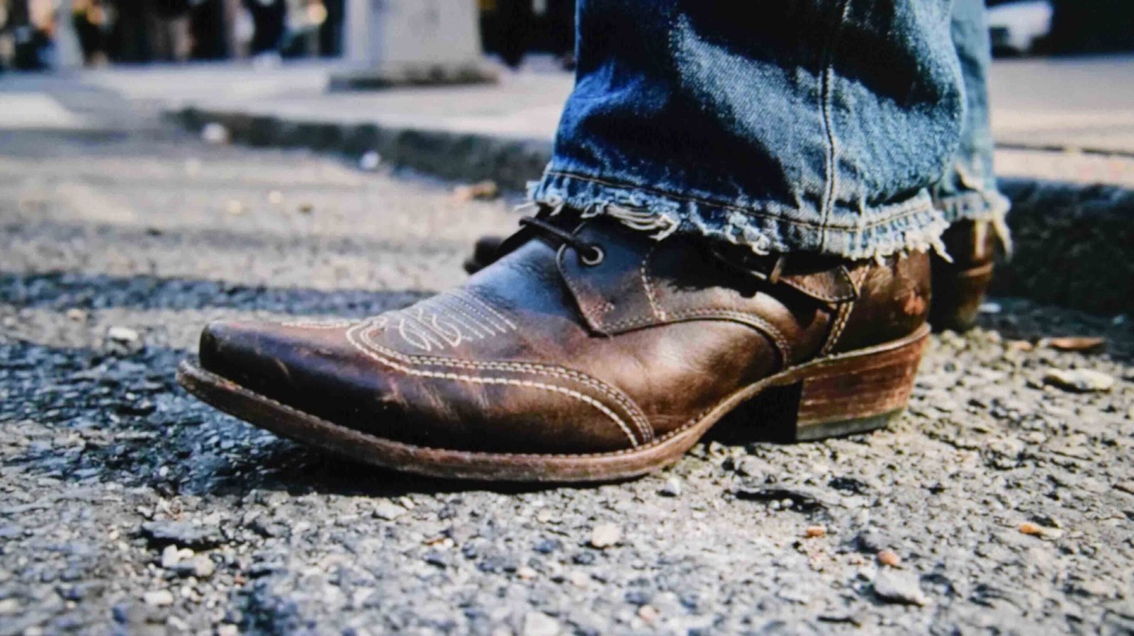 Pointed boots with toe detailing worn under loose denim to lengthen the leg