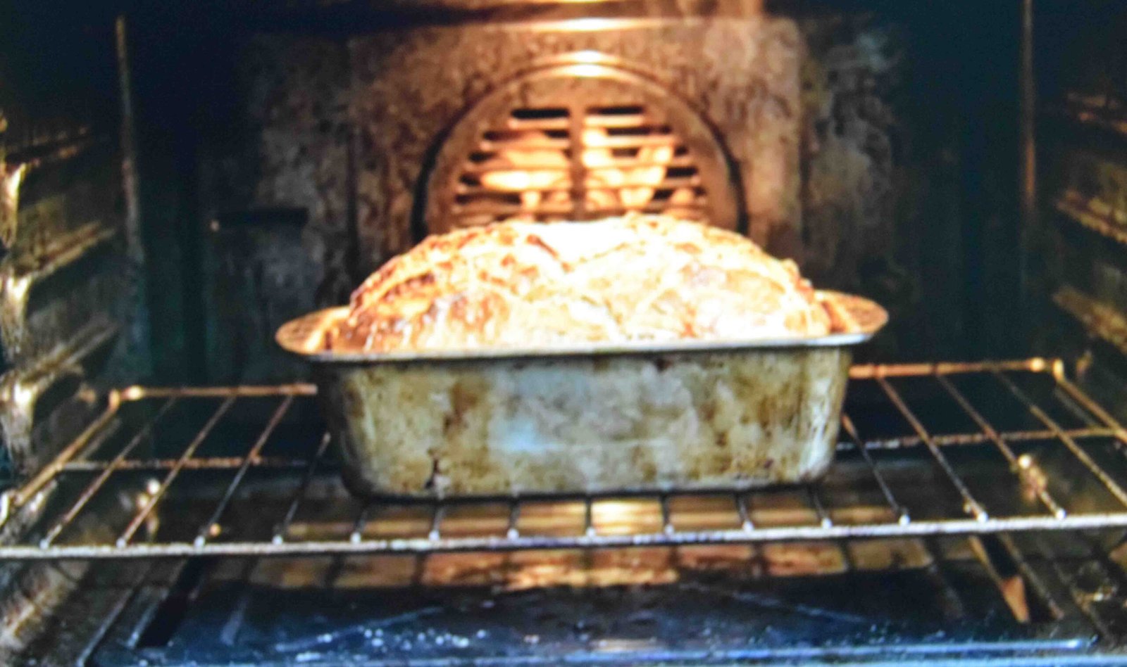 A loaf tin placed on the lower oven shelf so the base bakes through fully