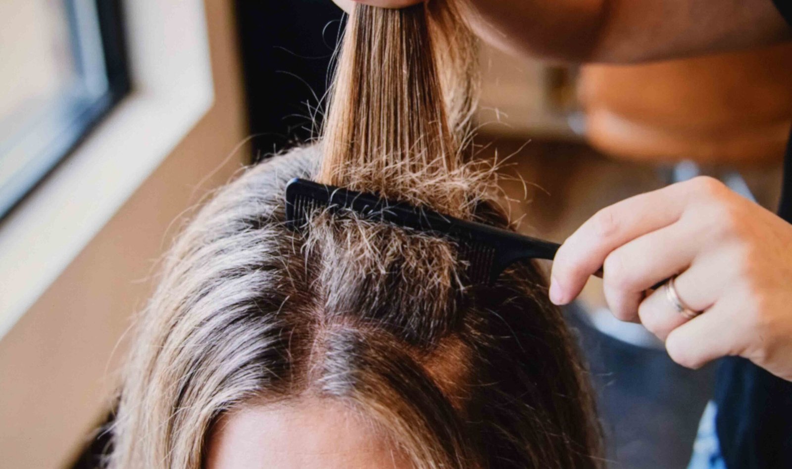 Backcombing at the root only to add volume where oily hair sits flat