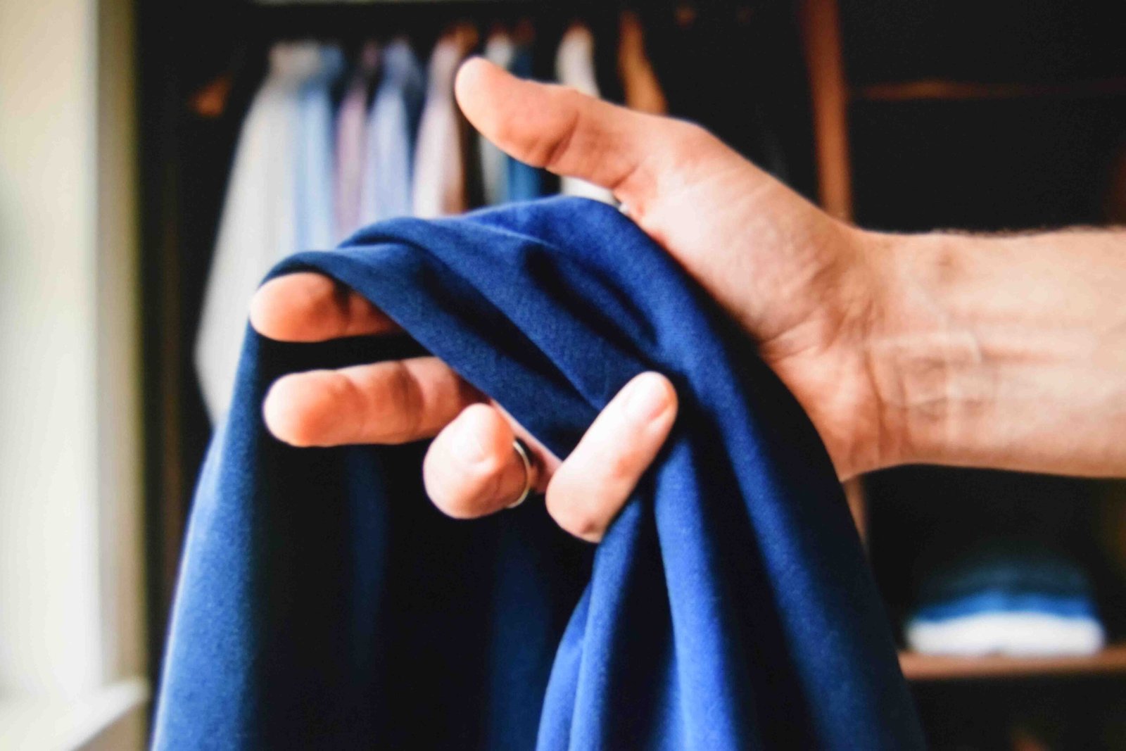 Squeeze testing travel trouser fabric to check how quickly creases drop out