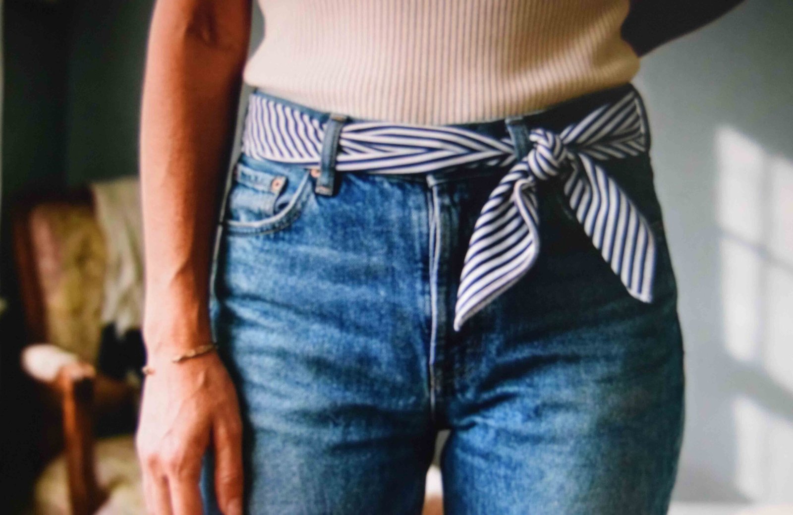 Cotton scarf folded into a band and threaded through denim belt loops with an off centre knot