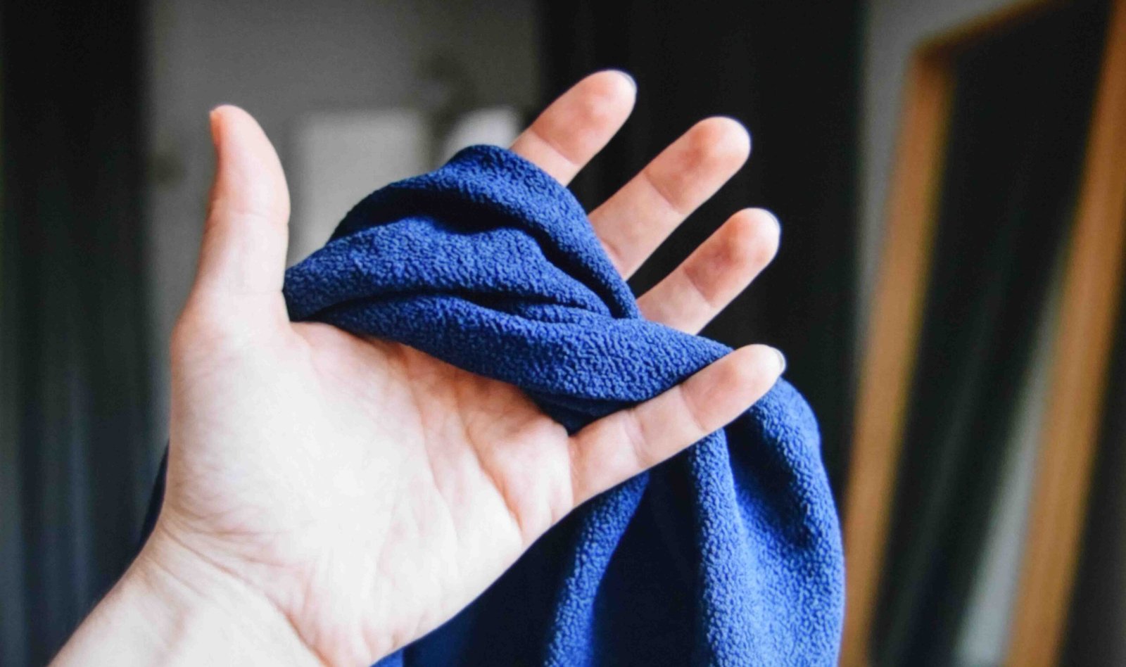 Squeeze testing dress fabric to check how quickly creases drop out
