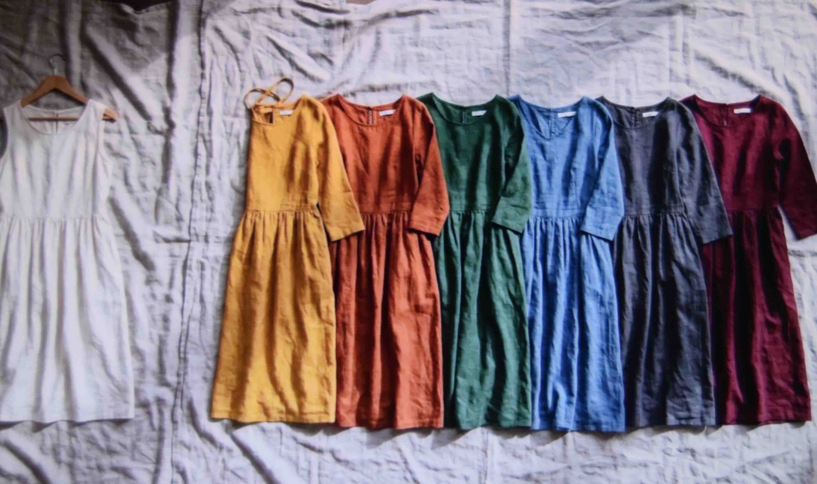 Dresses laid out with a cream one set aside to show which colours to avoid