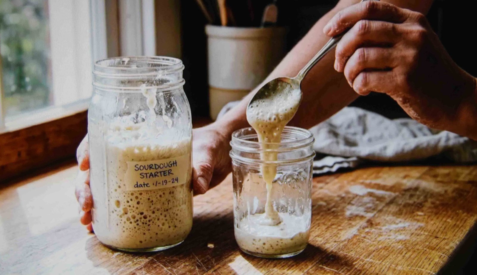 Removing a portion from a starter jar showing why you discard sourdough
